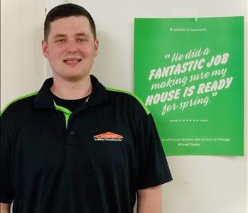 Male SERVPRO Employee standing in front of a sign