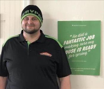 A SERVPRO employee is standing in front of a SERVPRO sign.