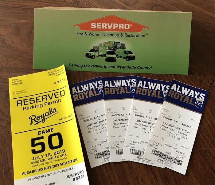 A SERVPRO table topper with a set of four Royals tickets in front of it