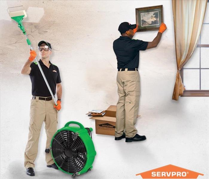 Two SERVPRO employees are cleaning smoke off the wall