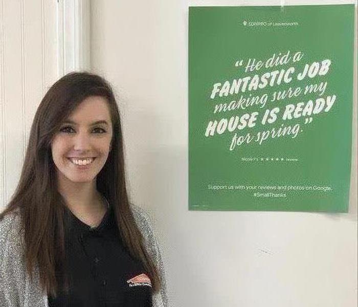 A SERVPRO employee standing in front of a sign